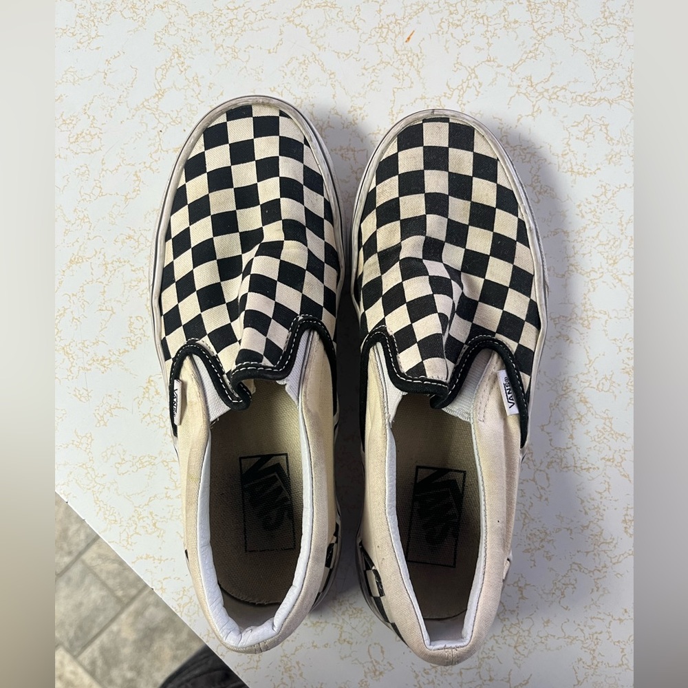 Black and white checkerboard vans slip on